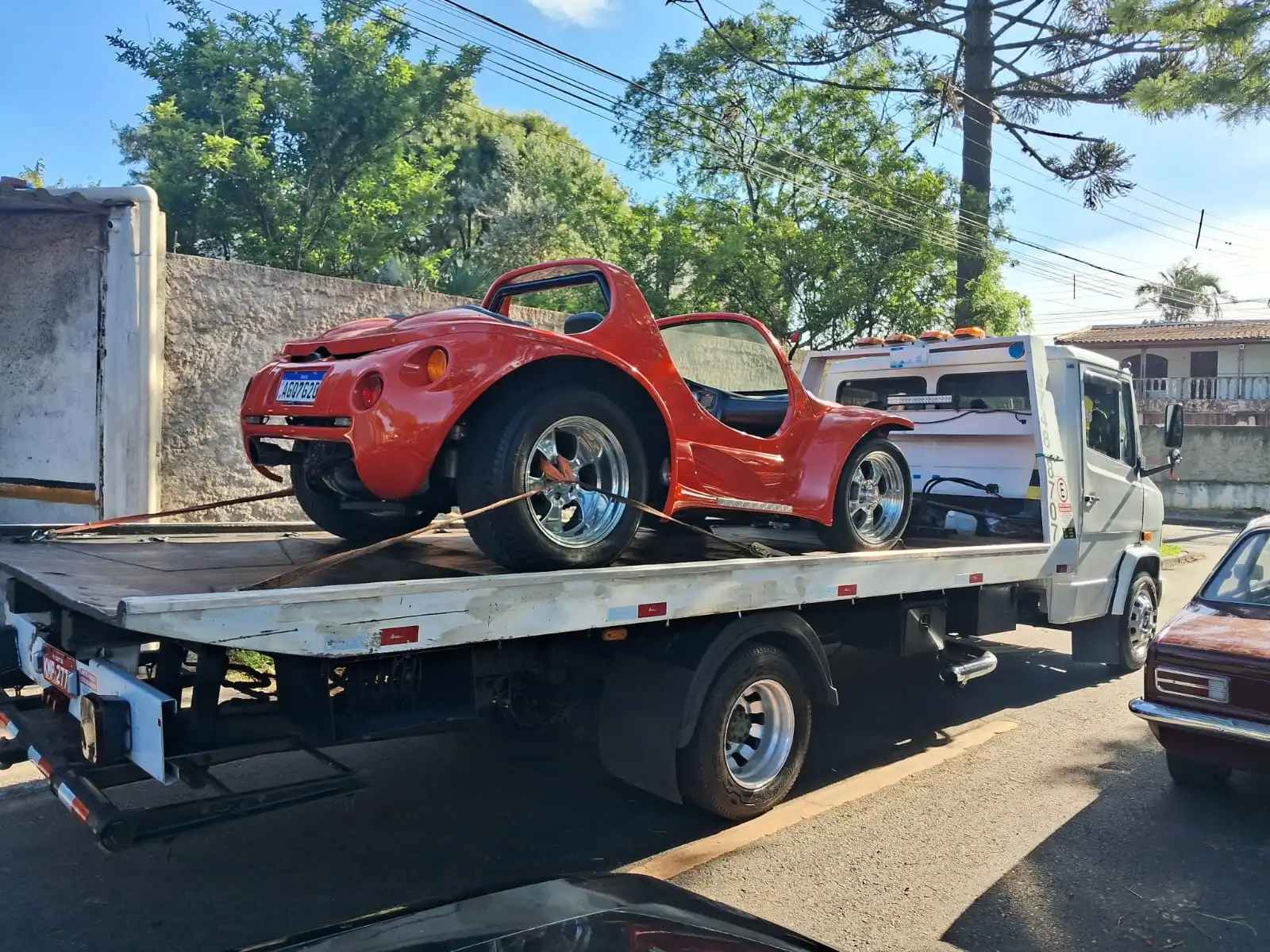 Guincho realizando reboque de buggy vermelho em área urbana de Curitiba