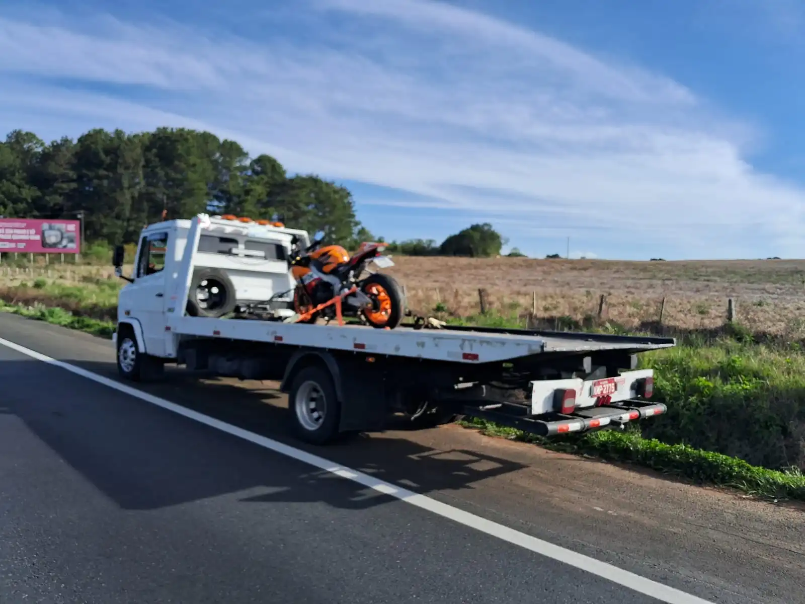 Guincho transportando motocicleta laranja em rodovia da região metropolitana de Curitiba